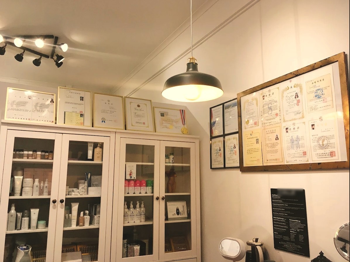 Inside the clinic: a wall of framed certificates above glass cabinets of skin care products